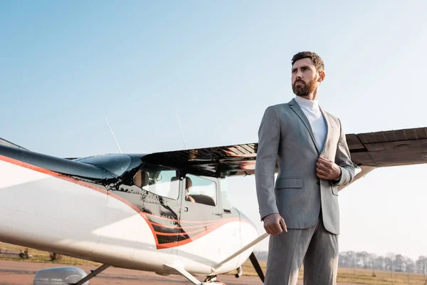 Visão de baixo ângulo de empresário bem sucedido em terno de pé perto de helicóptero ao ar livre — Fotografia de Stock