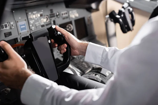 Partial view of pilot using yoke in airplane simulator — Stock Photo