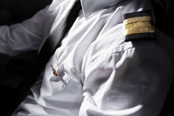 Sunshine on badge and uniform on professional pilot in airplane — Stock Photo