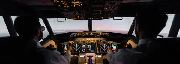 Vista posterior de los profesionales que pilotean el avión, bandera - foto de stock