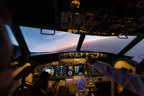 Vista recortada de profesionales pilotando avión por la noche - foto de stock