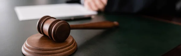 Wooden gavel on desk near cropped judge on blurred background, banner — Stock Photo