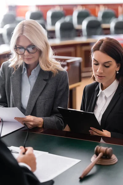 Prosecutor and advocate reading documents near judge in courtroom — Stock Photo