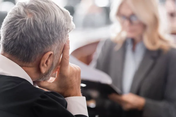 Messa a fuoco selettiva del giudice dai capelli grigi vicino avvocato offuscata in aula — Foto stock