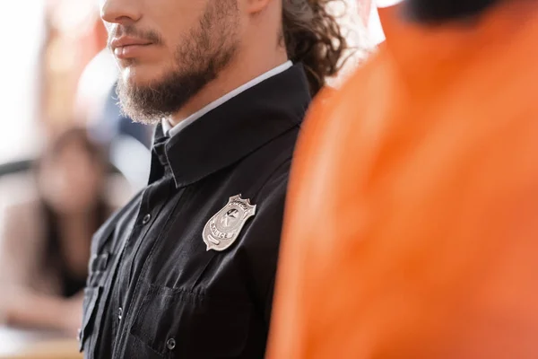 Teilansicht des bärtigen Gerichtsvollziehers in schwarzer Uniform vor Gericht — Stockfoto