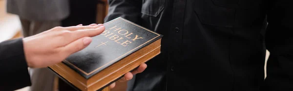 Vue partielle de la femme prêtant serment sur la sainte Bible au tribunal, bannière — Photo de stock