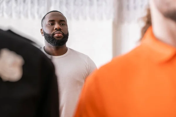 Selective focus of african american juryman near bailiff and accused man on blurred foreground — Stock Photo