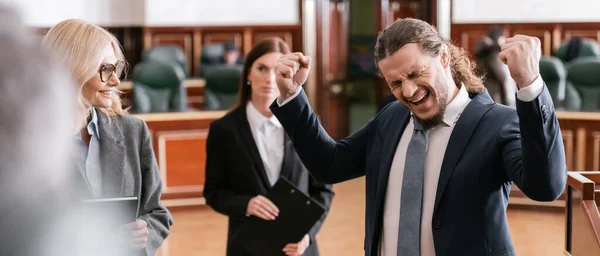 Heureux justifiés homme d'affaires crier tout en montrant geste de victoire au tribunal, bannière — Photo de stock