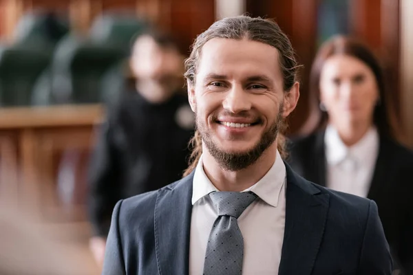 Empresário feliz sorrindo no tribunal em fundo turvo — Fotografia de Stock