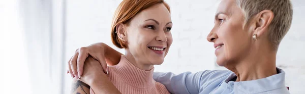 Alegres mujeres lesbianas sonriéndose en casa, pancarta - foto de stock