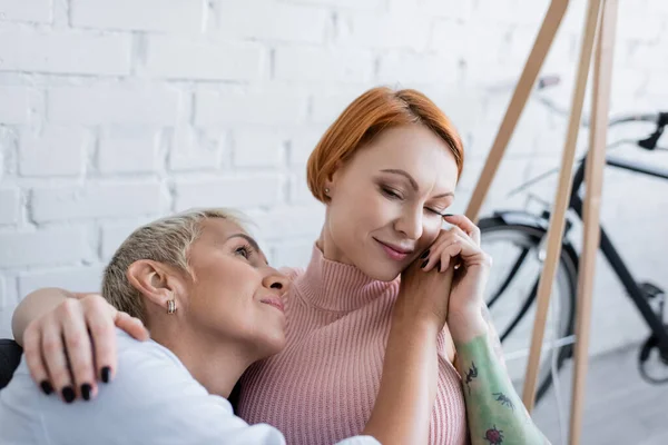 Lesbische Frau berührt Gesicht tätowierter Freundin zu Hause — Stockfoto