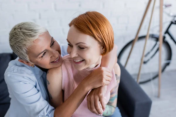 Glückliche Frau umarmt lesbische Freundin zu Hause — Stockfoto