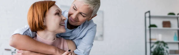 Femmes lesbiennes souriantes se regardant à la maison, bannière — Photo de stock