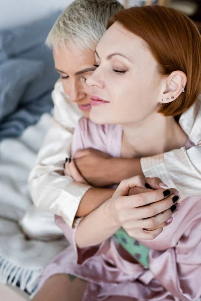 Размытая лесбиянка, обнимающая подружку в постели дома — стоковое фото
