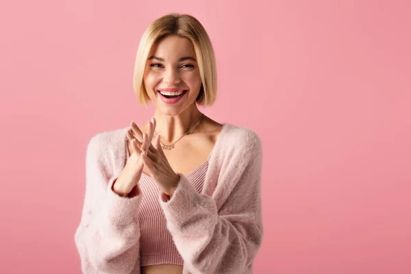 Fröhliche junge Frau in weicher Strickjacke auf rosa — Stockfoto