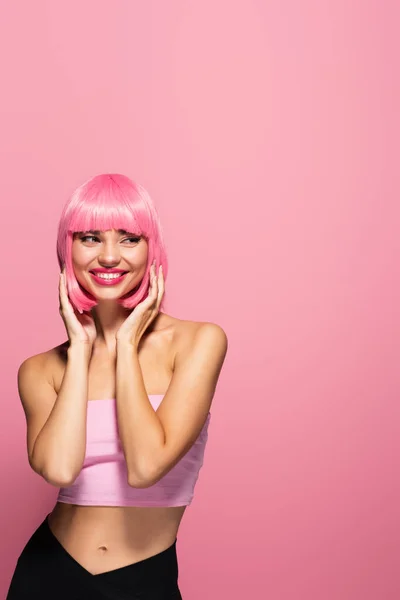 Alegre joven mujer con flequillo y pelo de color aislado en rosa - foto de stock