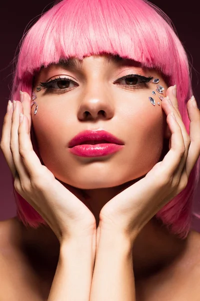 Vista de cerca de la mujer con el pelo rosa y piedras brillantes de la joyería en la cara - foto de stock