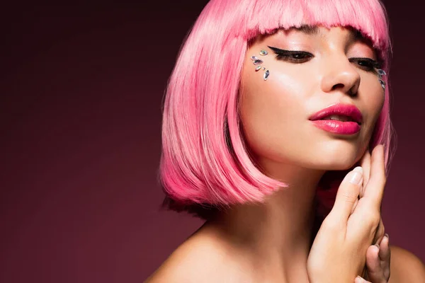 Giovane donna con capelli colorati e pietre lucide sul viso su viola scuro — Foto stock