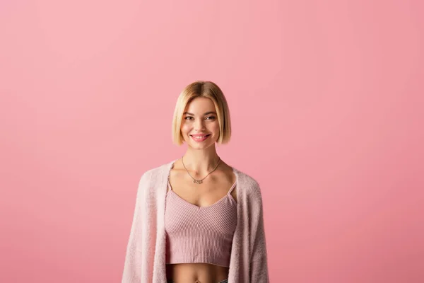 Mujer joven y alegre en suave cárdigan aislado en rosa — Stock Photo