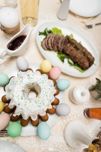 Vista superior de delicioso bolo de Páscoa perto de ovos pintados na mesa servida com jantar de Páscoa — Fotografia de Stock
