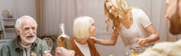 Mujer feliz hablando con la madre mayor durante la cena de Pascua, pancarta - foto de stock