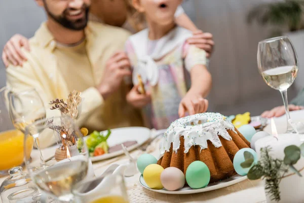 Vista recortada de chica borrosa señalando pastel de Pascua cerca de padre sonriente — Stock Photo