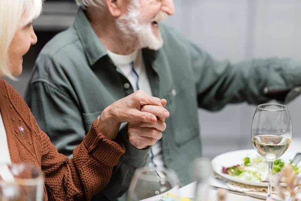 Happy senior couple holding hands during easter celebration at home — Stock Photo