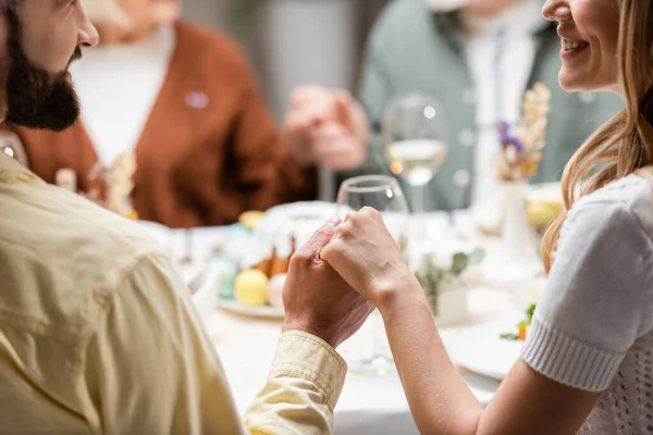 Cropped view of smiling couple holding hands during easter celebration — Stock Photo