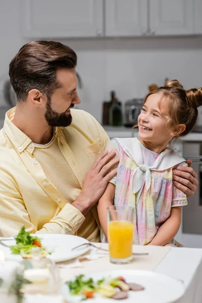 Felice uomo abbracciare preteen figlia durante la cena di Pasqua a casa — Foto stock