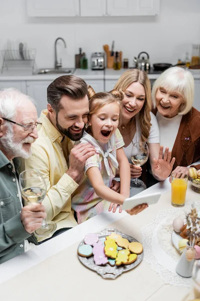 Joyful girl with open mouth taking selfie on smartphone with family during easter celebration — Stock Photo