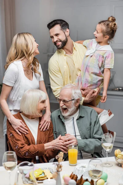 Parejas alegres mirándose durante la celebración de Pascua en casa - foto de stock