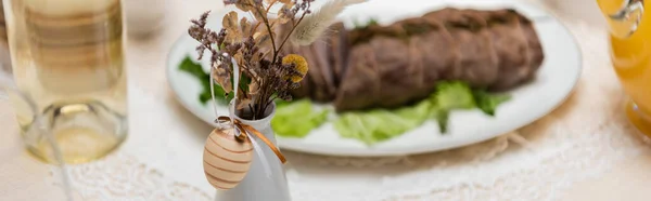 Enfoque selectivo de huevo decorativo y plantas secas cerca de la carne frita sobre fondo borroso, pancarta - foto de stock