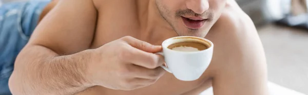 Partial view of shirtless man holding cup of coffee, banner — Stock Photo
