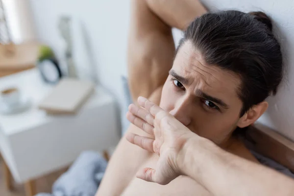 High angle view of tired and shirtless man yawning and covering mouth at home — Stock Photo