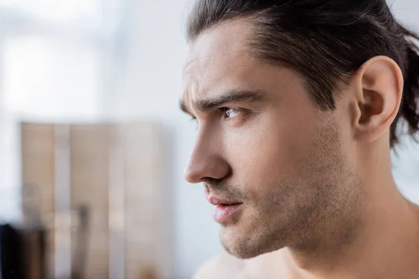 Gros plan de l'homme aux cheveux longs regardant loin à la maison — Photo de stock