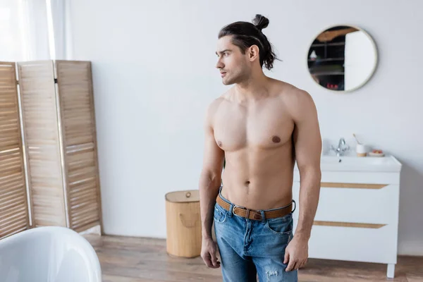 Shirtless man with long hair standing in modern bathroom — Stock Photo