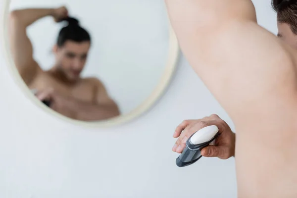 Homem desfocado aplicando desodorizante no banheiro — Fotografia de Stock