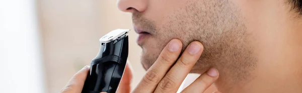 Cropped view of man shaving with electric razor, banner — Stock Photo