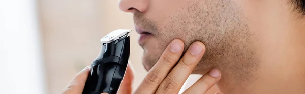 Vue recadrée de l'homme rasage avec rasoir électrique, bannière — Photo de stock