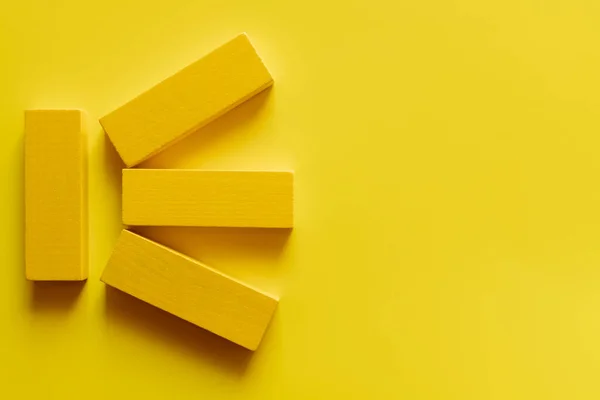 Вид сверху на яркие цветные блоки на желтом фоне — стоковое фото