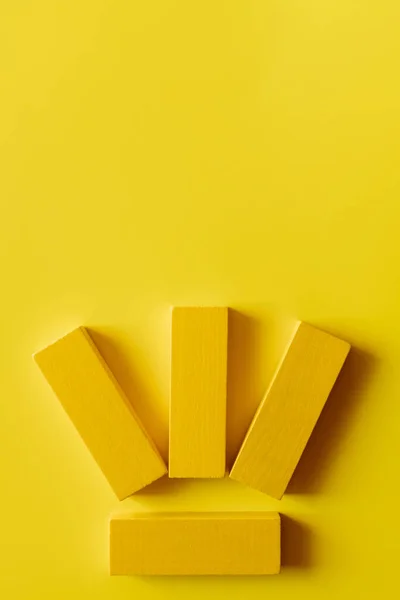 Vue de dessus de quatre blocs colorés sur fond jaune — Photo de stock