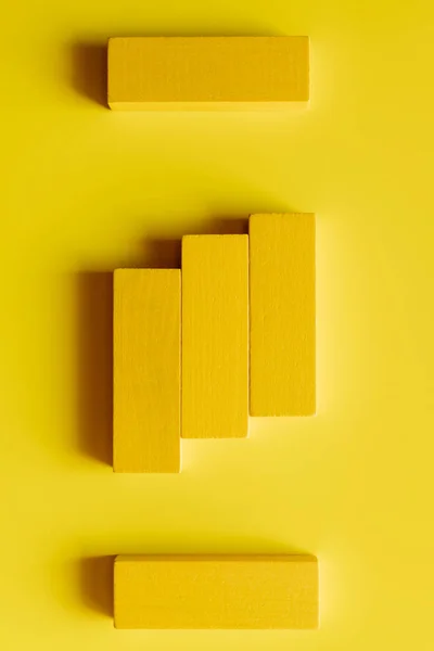 Vista superior de bloques tetragonales brillantes sobre fondo amarillo - foto de stock