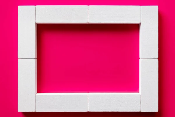 Vista dall'alto di blocchi bianchi cornice su sfondo rosa — Foto stock