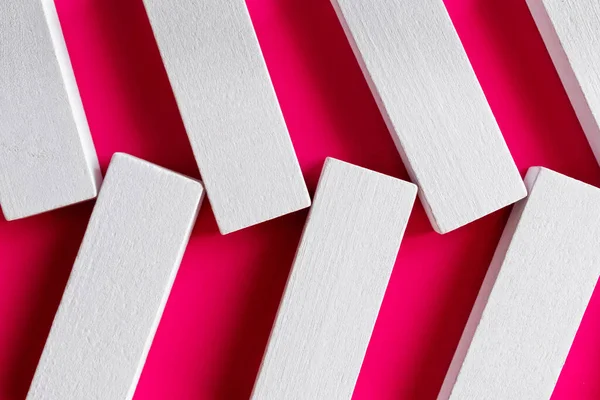 Close up of white quadrangular blocks on pink background, top view — Stock Photo