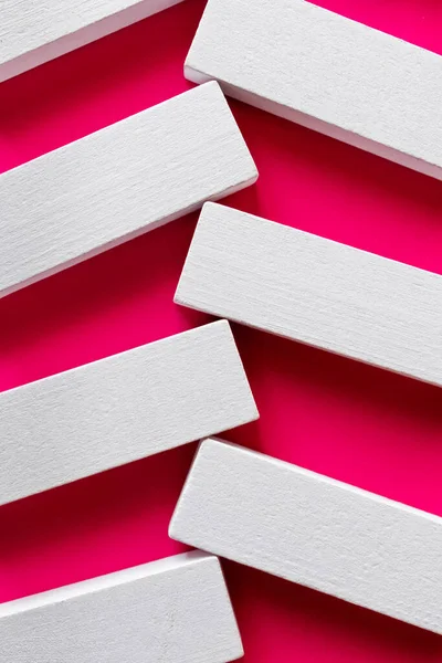 Primer plano de bloques blancos sobre fondo rosa brillante, vista superior - foto de stock
