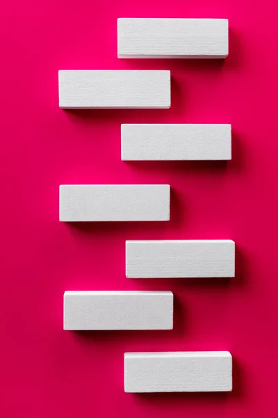 Draufsicht auf weiße tetragonale Blöcke auf leuchtend rosa Hintergrund — Stockfoto
