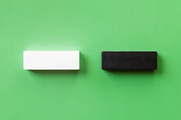 Top view of two white and black blocks on green background — Stock Photo