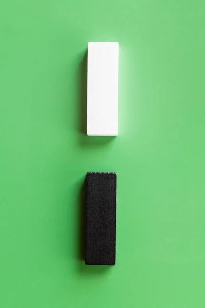Top view of vertical line of white and black blocks on green background — Stock Photo