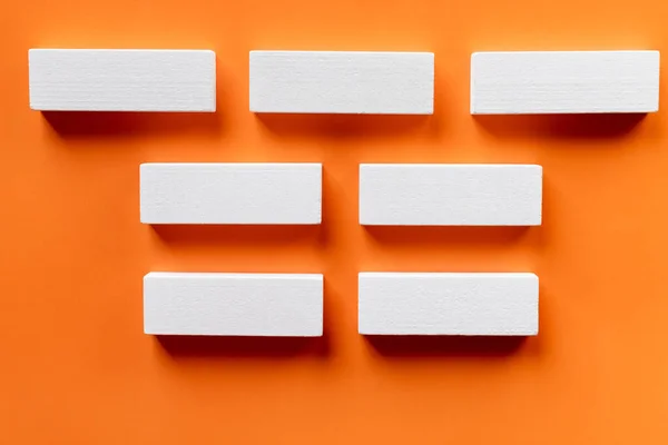 Top view of white blocks horizontal lines on orange background — Stock Photo