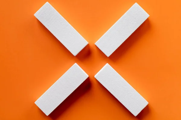 Draufsicht auf weiße tetragonale Blöcke auf leuchtend orangefarbenem Hintergrund — Stockfoto